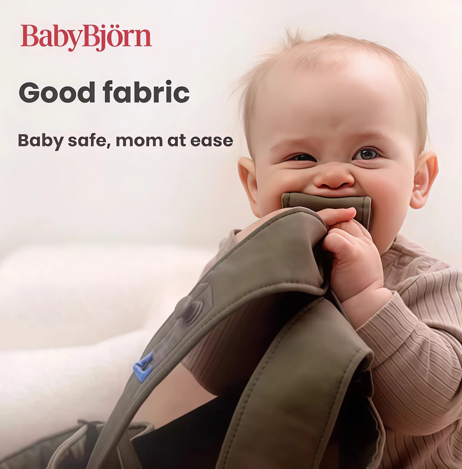 Happy baby chewing on BabyBjörn Harmony Carrier Mesh strap – made with safe, non-toxic, OEKO-TEX certified fabric for baby comfort and mom’s peace of mind