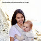 Mother carrying baby in Ergobaby Omni Classic Mesh Carrier at beach—lightweight, breathable mesh fabric provides cool, comfortable sensation during outdoor activities.