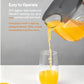  A hand easily pouring juice from the Joyoung Y3's lightweight pitcher into a glass, showcasing the easy-to-operate design for one-handed pouring.