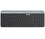 Overhead shot of the graphite Logitech K580 slim wireless keyboard, featuring a built-in phone/tablet cradle, full-size layout with numeric keypad, and dual-connectivity indicators.