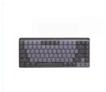 Hero shot of the Logitech MX Mechanical Mini wireless keyboard in pale gray, floating above colorful 3D shapes, highlighting its compact 75% layout and backlit keys.