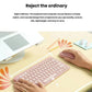  Lifestyle photo of the rose Pebble 2 Combo in use on a pastel desk with a laptop, notebooks, and pencils, emphasizing its lightweight, portable design.
